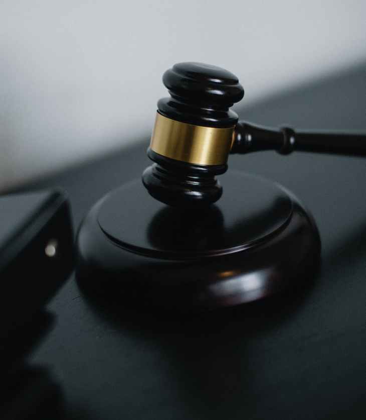 small judge gavel placed on table near folders