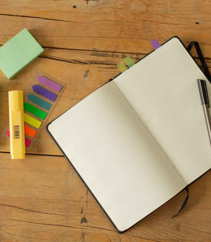 opened notebook with white blank pages and pen on table