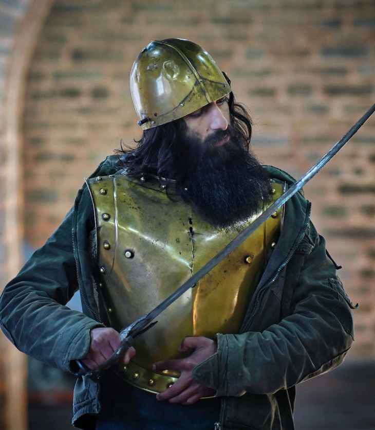 a man wearing bronze helmet holding a sword